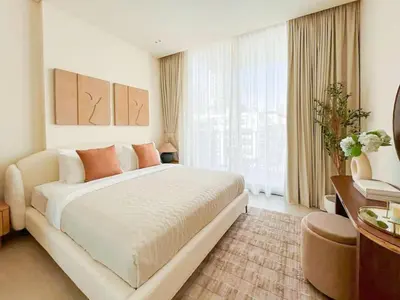 a bedroom with a large bed and a large window at Warm Modern 1BR Haven with Balcony & Free Parking in Dubai