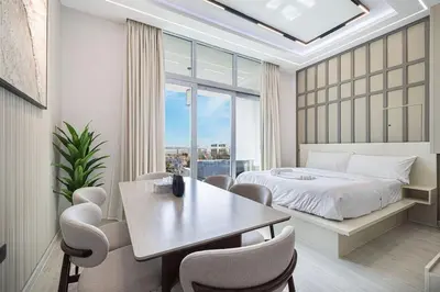 a bedroom with a bed and a table and chairs at 3BHK Near Beach High Floor Marina Stay DEC 1203 Tower 1 in Dubai