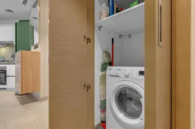 a laundry room with a washer and dryer at Waves - Elegant High-Floor 2BR Close To Downtown in Dubai