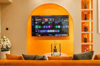 a waiting room with orange couches and a flat screen tv at Stylish 2BHK Central Marina Rooftop Pool DEC T1 601 in Dubai
