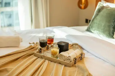 a tray with drinks and towels on a bed at Stylish 2BHK Central Marina Rooftop Pool DEC T1 601 in Dubai