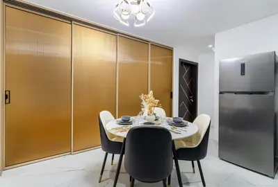 a dining room with a table and a refrigerator at Luxury 1 BHK in Al Barsha by Opalz by Danube 1607 in Dubai