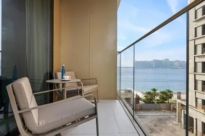 a balcony with a chair and a table with a view at Luxury one bed flat in Dubai Harbour in Dubai