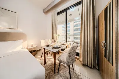 a bedroom with a bed and a table and chairs at New Bright Studio in Escan Tower, For 2, Dubai Marina in Dubai