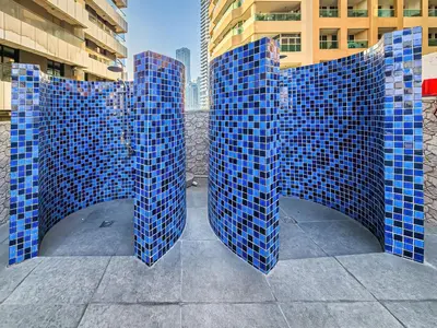 a sculpture of blue tiles on the side of a building at New Bright Studio in Escan Tower, For 2, Dubai Marina in Dubai