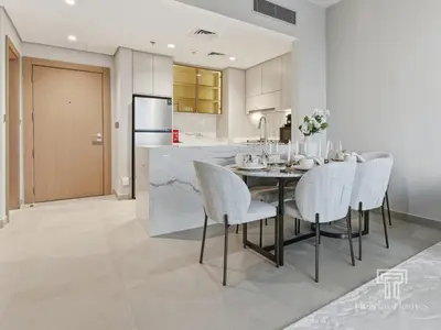 a kitchen and dining room with a table and chairs at Brand New 2 Bed Contemporary Apt-Gym Pool Access in Dubai