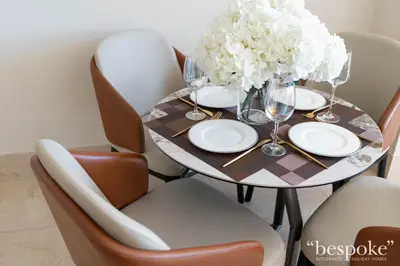 a dining room table with plates and glasses and flowers at Bespoke Holiday Homes - Elegant 2BR with Terrace in The 8 Palm Jumeirah in Dubai