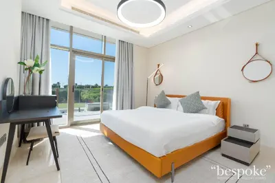 a bedroom with a bed and a desk and a window at Bespoke Holiday Homes - Elegant 2BR with Terrace in The 8 Palm Jumeirah in Dubai