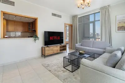 a living room with a couch and a tv at Greens Haven City & Golf View Balcony in Dubai