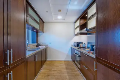 a large kitchen with wooden cabinets and wooden floors at GlobalStay Luxury Apartments The Residences Tower 8 Downtown Dubai in Dubai