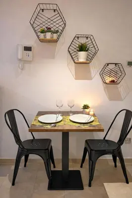 a dining room table with two chairs and plates and glasses at Cozy Studio in Downtown, Short walk to Burj Khalifa in Dubai