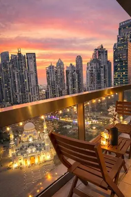 a balcony with a view of a city at sunset at Cozy Studio in Downtown, Short walk to Burj Khalifa in Dubai