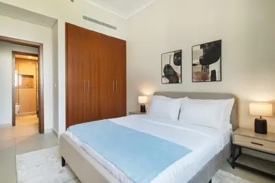 a bedroom with a large white bed and two lamps at Rare 4BR Vida Golf & Pool View in Dubai