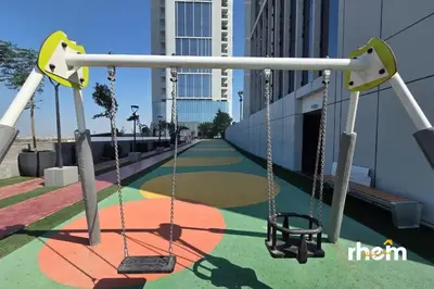 a swing set on a playground in a city at Brand New 1-BR with Marina and JLT Balcony Views in Dubai