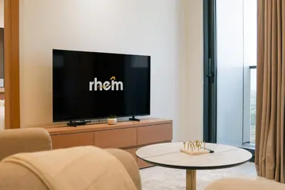 a living room with a tv and a table at Brand New 1-BR with Marina and JLT Balcony Views in Dubai