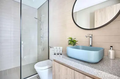 a bathroom with a sink and a toilet and a mirror at Frank Porter - Peninsula One in Dubai