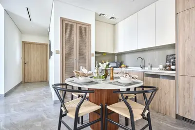 a kitchen with a table and chairs in a room at Frank Porter - Peninsula One in Dubai