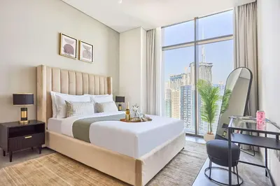 a bedroom with a large bed and a large window at Frank Porter - Peninsula One in Dubai