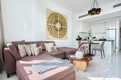 a living room with a brown couch and a table at Frank Porter - Damac Ghalia in Dubai