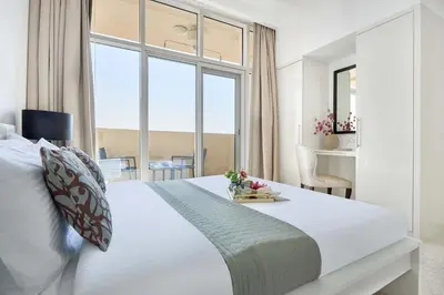 a bedroom with a large white bed and a window at Frank Porter - Damac Ghalia in Dubai