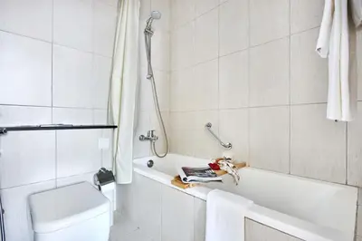 a bathroom with a shower and a tub and a toilet at Frank Porter - Damac Ghalia in Dubai
