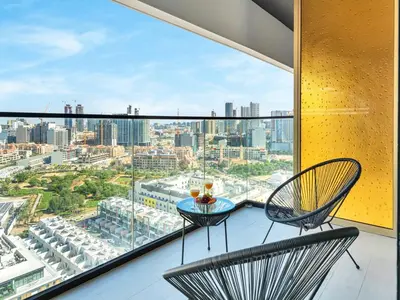 a balcony with two chairs and a view of the city at Premium 2BD with Balcony Pool & Gym in Dubai