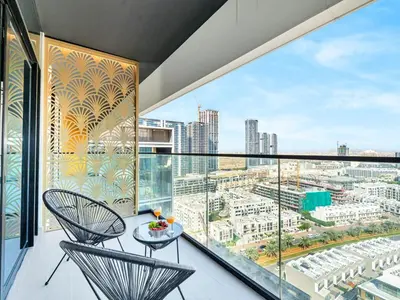 a balcony with two chairs and a view of a city at Premium 2BD with Balcony Pool & Gym in Dubai