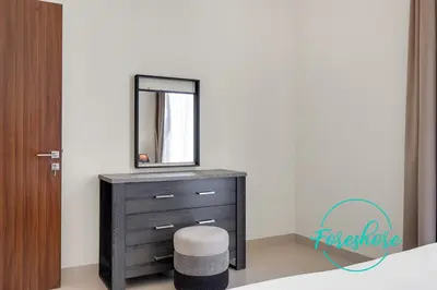 a bedroom with a dresser with a mirror and a stool at Ultra Luxury Villa 5BR With Maid Room in Dubai