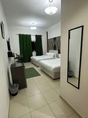 a large bedroom with two beds and a mirror at AlWasl Guesthouse by PHM in Dubai