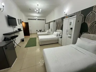 a bedroom with two beds and a living room at AlWasl Guesthouse by PHM in Dubai
