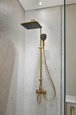 a shower with a brass shower head in a bathroom at Golden Stays - Private Pool Modern 2BR Oasis in JVC in Dubai