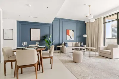a living room with a table and chairs and a couch at Silkhaus Luxurious 1BDR with Sea View in Emaar in Dubai