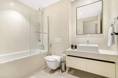 a bathroom with a toilet and a sink and a bath tub at Silkhaus Luxurious 1BDR with Sea View in Emaar in Dubai