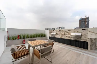 a patio with a table and chairs on a roof at Arjan's Chic Studio with Cinema and Game Room in Dubai