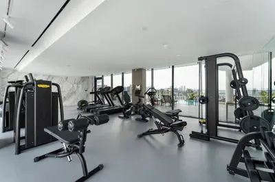 a gym with a bunch of treadmills and machines at Arjan's Chic Studio with Cinema and Game Room in Dubai