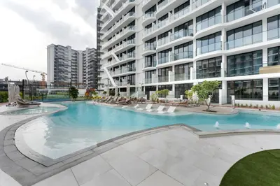 a large swimming pool in front of a building at Arjan's Chic Studio with Cinema and Game Room in Dubai
