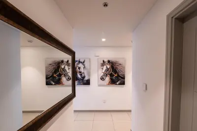 a hallway with three paintings of horses on the wall at Forte 3BR Luxury PS5 Gaming Room Sleeps 9 in Dubai