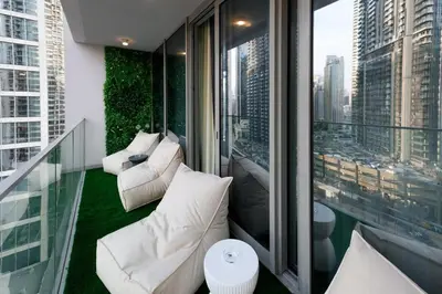 a balcony with white furniture and a view of a city at Forte 3BR Luxury PS5 Gaming Room Sleeps 9 in Dubai