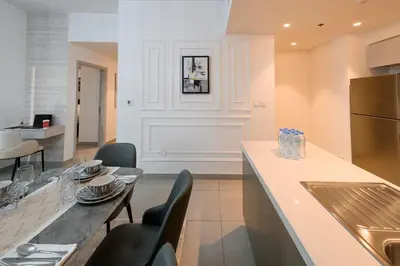 a kitchen with a table and chairs and a counter at Forte 3BR Luxury PS5 Gaming Room Sleeps 9 in Dubai