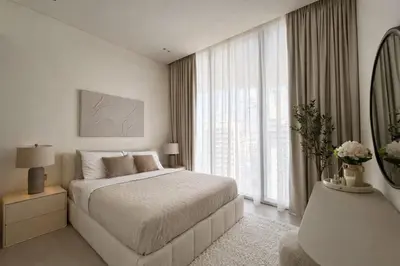 a white bedroom with a bed and a window at Stylish Stay with Plunge Pool & Scenic Pool View in Dubai