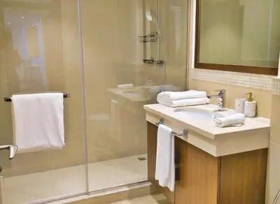 a bathroom with a shower and a sink and a mirror at Burj VIsta 3 Bedroom - With spectacular Views in Dubai