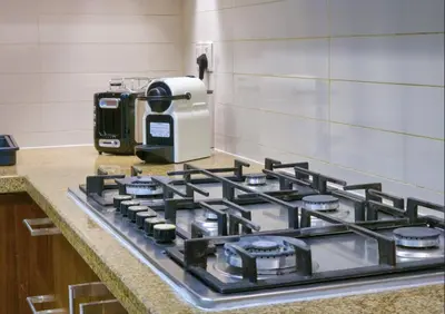 a kitchen counter with a stove and a coffee maker at Burj VIsta 3 Bedroom - With spectacular Views in Dubai