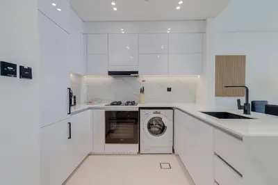 a white kitchen with a washing machine in it at Binghatti House, JVC - 1 Bedroom Apartment - Allsopp & Allsopp in Dubai