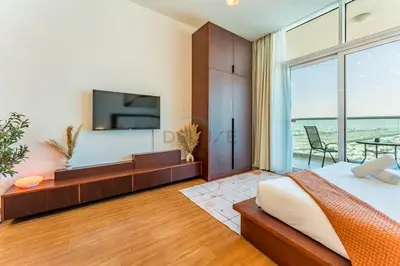 a bedroom with a large bed and a large window at Skyline Studio Overlooking the Community, Only a Few Steps from the Park, Al Jawhara Tower, Jumeirah Village Triangle by Deluxe Holiday Homes in Dubai