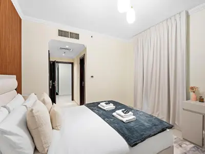 a bedroom with a white bed with towels on it at Charming and Vibrant Living 1BDR In Marina Quay in Dubai