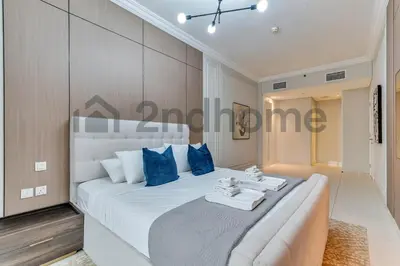 a bedroom with a large white bed with blue pillows at Business Bay Fully Equipped 2 Bedroom Capital Bay in Dubai
