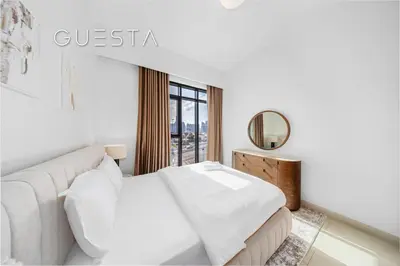 a white bedroom with a white couch and a window at Vida The Hills Residences, Dubai in Dubai