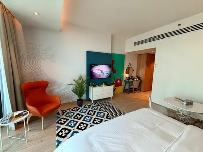 a bedroom with a bed and a tv on a wall at The Sky in Dubai