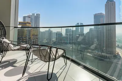 a balcony with a chair and a view of the city at High Floor Unit with Canal View, A Minutes Drive to Dubai Mall - Zada Tower, Business Bay by Deluxe Holiday Homes in Dubai