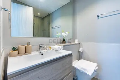 a white bathroom with a sink and a mirror at High Floor Unit with Canal View, A Minutes Drive to Dubai Mall - Zada Tower, Business Bay by Deluxe Holiday Homes in Dubai